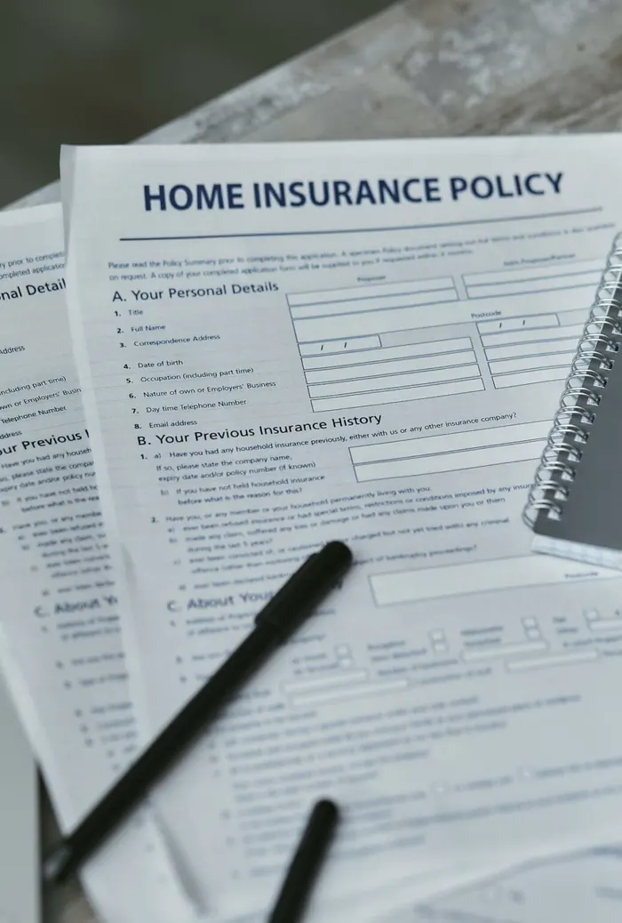 Un formulaire d'assurance habitation posé sur une table, avec un stylo et un carnet.