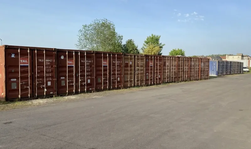 La longue rangée de garages le long de l'allée goudronnée, assez large pour se garer devant sa porte.